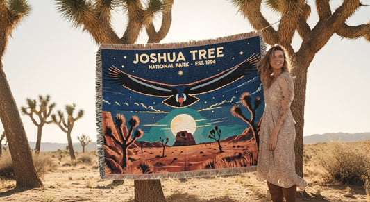 Woman holding a 'Joshua Tree National Park' blanket in a desert setting