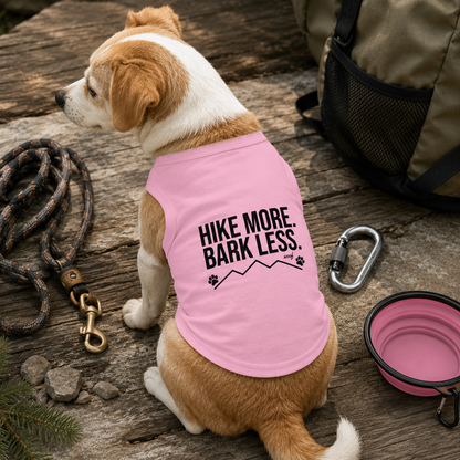 Dog wearing pink shirt with "Hike More. Bark Less." text and mountain graphic.