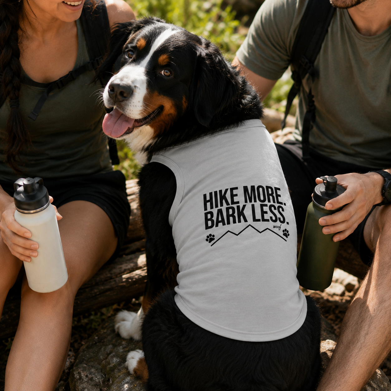 Bernese Mountain Dog wearing a white tank top with "HIKE MORE. BARK LESS." text.