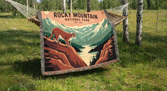 Blanket with Rocky Mountain National Park design draped over a hammock in a natural setting.