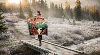 Person holding a Rocky Mountain National Park blanket in a forest setting