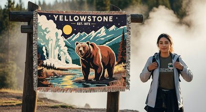 Woman standing next to a 'Yellowstone' sign with a bear illustration in a natural setting.