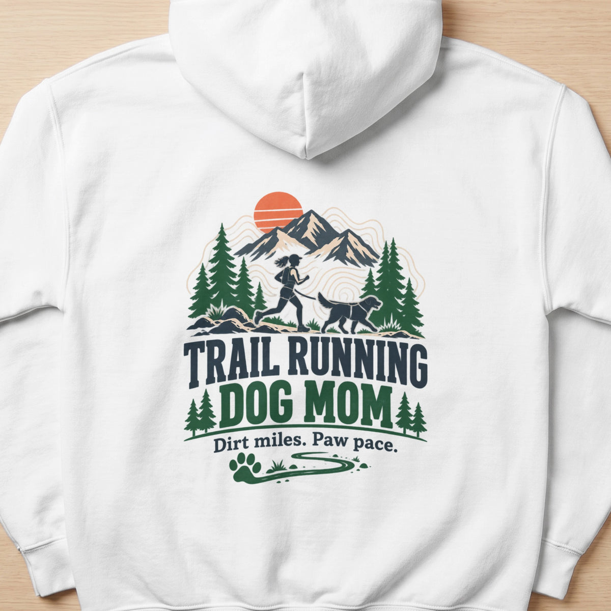White hoodie with "TRAIL RUNNING DOG MOM" graphic and mountain scene.