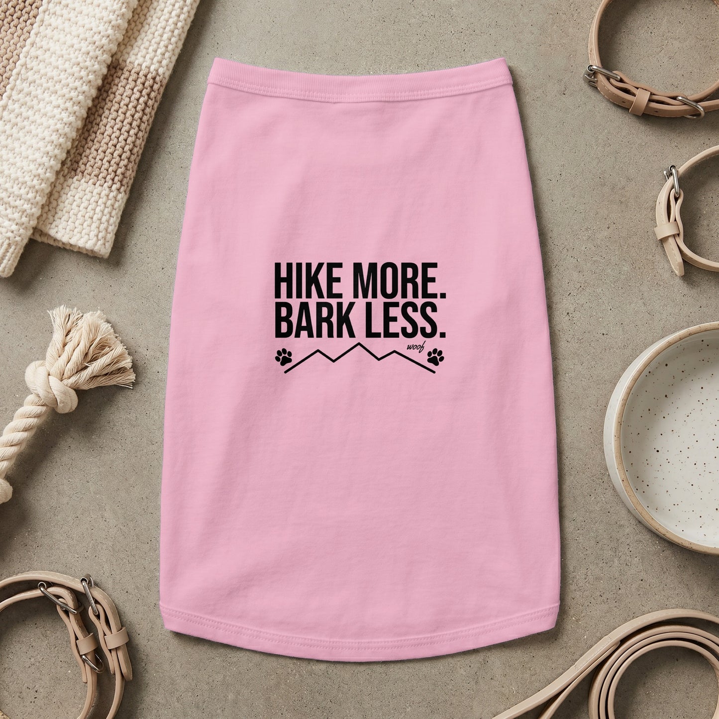 Pink dog shirt with "HIKE MORE. BARK LESS." text, paw prints, and mountains.